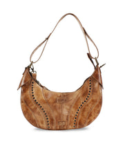 Introducing the Megara by Bed|Stü—a brown leather saddle bag with curved decorative stitching, metal stud accents, an adjustable strap, and a worn finish. This stylish shoulder bag features refined leather details for a sophisticated touch.