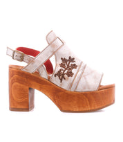 Melodramatic by Bed|Stü is a beige leather platform sandal with a chunky heel and wooden sole, showcasing floral embroidery on the side and an adjustable ankle strap.