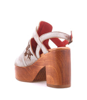 The Melodramatic by Bed|Stü is a silver high-heeled shoe with a chunky leather heel and wooden platform, showcasing floral embroidery and a red interior lining, shown here from the back.