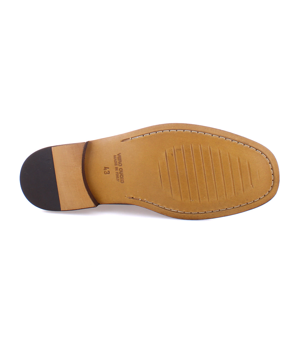 The underside of the Moat loafer by Bed|Stü, crafted from tan Italian leather, showcases a black heel, visible stitching, and horizontal grooves across the forefoot.