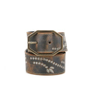 Bed|Stü's Mohawk belt showcases a western-inspired style with distressed brown leather, a metallic rectangular buckle, and a decorative white dotted pattern.