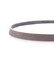 A close-up of the Bed|Stü Monae slim leather belt, featuring a timeless buckle and arranged in a circular shape on a white background—a must-have accent for any everyday wardrobe.