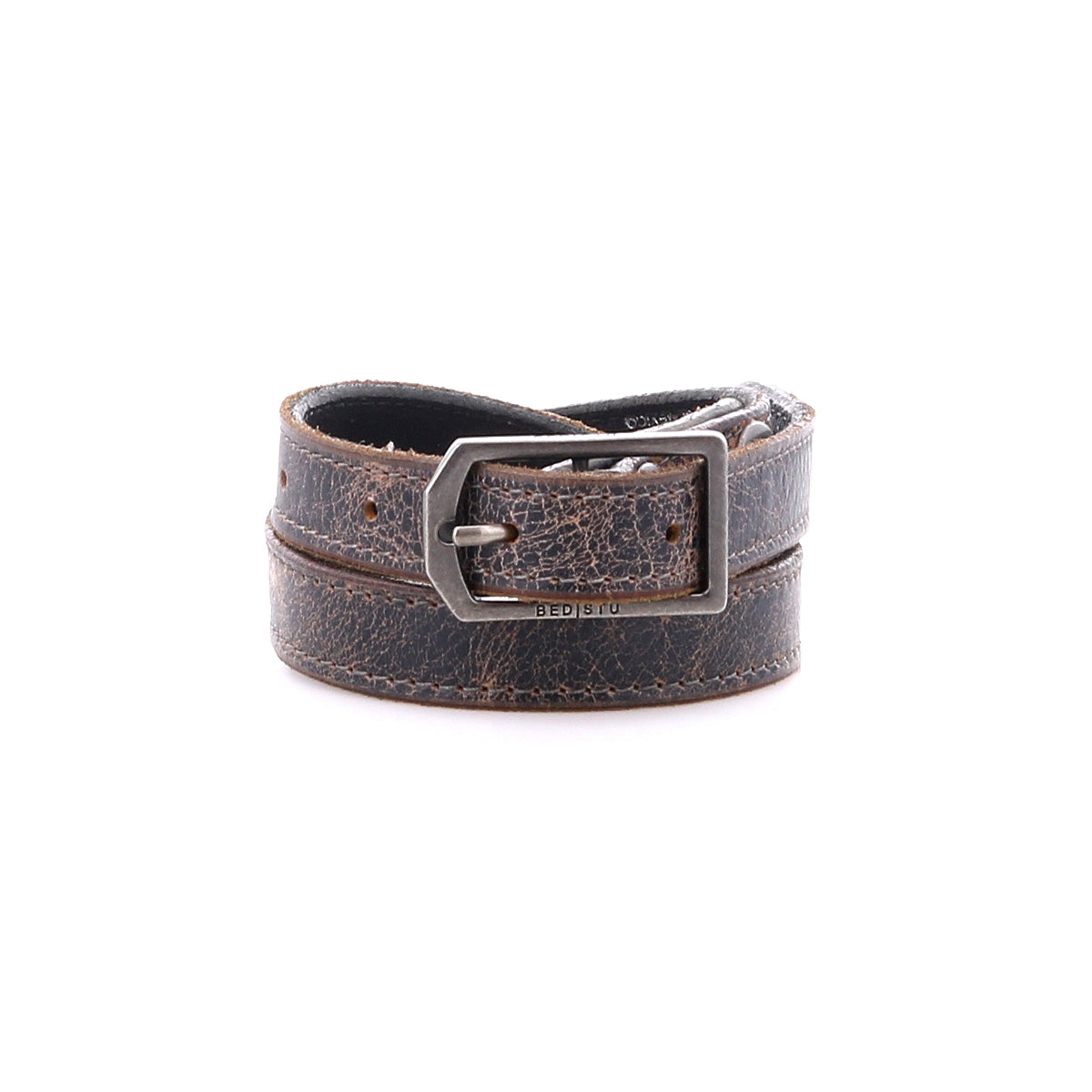 The Monae by Bed|Stü is a slim, brown distressed leather belt featuring a classic silver rectangular buckle, shown rolled up against a plain white background—an essential piece for any everyday wardrobe.