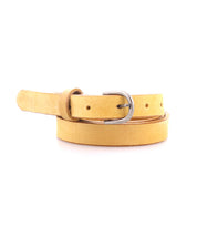 The Monae by Bed|Stü is a yellow suede slim leather belt featuring a timeless buckle, elegantly coiled on a white background—making it a standout accessory for your everyday wardrobe.
