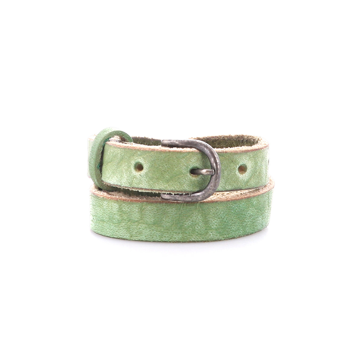 The Bed|Stü Monae belt, crafted from slim light green leather and finished with a classic silver buckle, is elegantly coiled against a white backdrop—an effortlessly stylish addition to any everyday wardrobe.