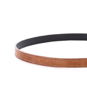 The Bed|Stü Monae women's leather belt, featuring a slim, curved design and visible stitching in brown, is displayed against a white background.
