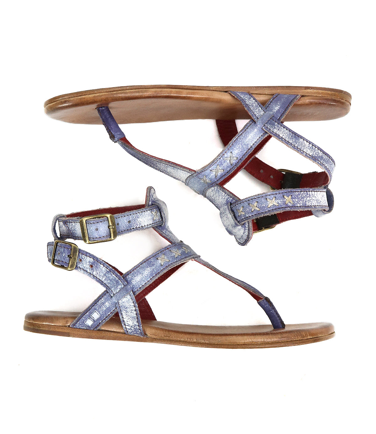 The Bed|Stü Moon sandals feature flat brown soles with a cushioned insole, metallic lavender leather straps adorned with gold-tone star accents, and secure ankle buckle closures, shown here in a side view.