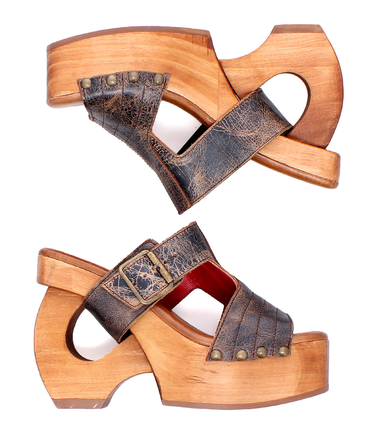 Bed|Stü’s Mutable sandals—a pair of vintage-inspired wooden platform sandals featuring distressed brown leather straps, decorative buckle, and metal stud detailing—are shown in profile on a white background, perfectly embodying the brand’s signature blend of classic influence and timeless style.