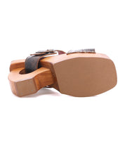 The Mutable sandal by Bed|Stü is a vintage-inspired wooden clog with a thick, flat sole and a dark strap adorned with a decorative buckle, shown here from the bottom.