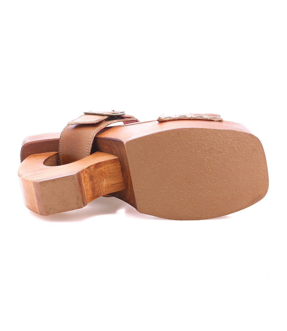 Introducing the Mutable sandal by Bed|Stü—a single wooden sandal with a brown sole and thick strap, displayed from a bottom angled view to showcase its distinctive curved heel design and vintage appeal. The wooden platform heel further accentuates this style’s retro charm.