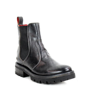 The Nandi III by Bed|Stü is a timeless black leather Chelsea boot with dual side gores, a red pull tab, round toe, and thick rubber sole, shown on a white background.