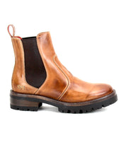 The Bed|Stü Nandi III is a brown leather Chelsea boot featuring dual black elastic side panels, a convenient heel pull tab, and a thick black rubber sole. Shown in profile against a white background, it offers a timeless silhouette.