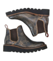 A pair of Bed|Stü Novel II distressed brown leather Chelsea boots with a leather upper, black elastic side panels, scalloped black rubber platform sole, and red-striped pull tabs, displayed side by side against a white background.