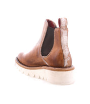 The Bed|Stü Novel II is a brown leather Chelsea boot featuring an elastic side panel, pull tab, and a thick white platform sole. Shown angled on a white background, its durable leather upper offers both style and longevity in this classic Chelsea design.