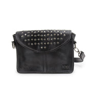 Bed|Stü’s Occurrence is a black leather compact crossbody bag, featuring silver studs on the flap, a detachable shoulder strap, and a stitched logo patch on the front. This versatile clutch transitions seamlessly from day to night.