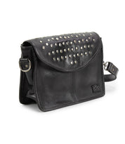 Introducing the Bed|Stü Occurrence crossbody, crafted from black leather and accented with silver studs along the flap. This compact bag features an adjustable strap and a subtle embossed logo on the front corner. Ideal as a studded everyday bag or carried as a sleek clutch for evenings out.