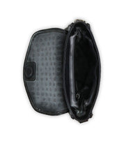 The Bed|Stü Occurrence, a compact black crossbody handbag, is photographed from above on a white background with its flap open to reveal a polka dot interior lining and a central zippered compartment.
