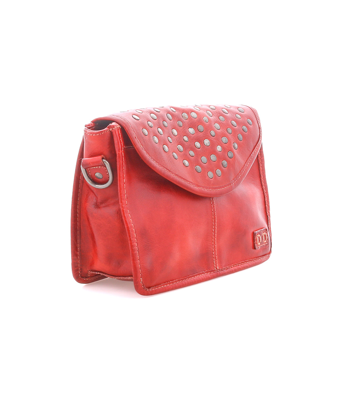 The Bed|Stü Occurrence is a red leather studded crossbody bag featuring silver studs on the flap, distinctive side strap detailing, and a small embossed logo on the lower front corner. This compact accessory is shown against a white background.