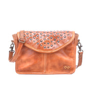 Introducing the Occurrence by Bed|Stü: a brown leather crossbody bag featuring a flap closure adorned with metal studs and an adjustable strap. Photographed on a white background, this compact accessory is perfect for elevating your everyday style.