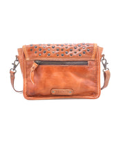 Bed|Stü Occurrence is a brown leather compact crossbody bag featuring metal studs on the flap, a front zipper pocket, and a BED|STU logo patch at the bottom center.