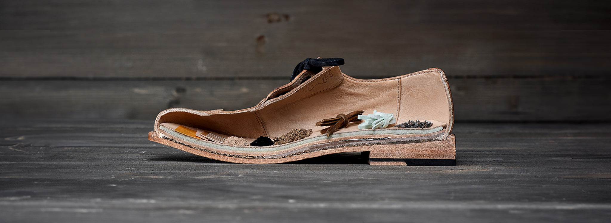 Cross-section of a leather shoe showing the layers, stitching, heel, and materials inside.