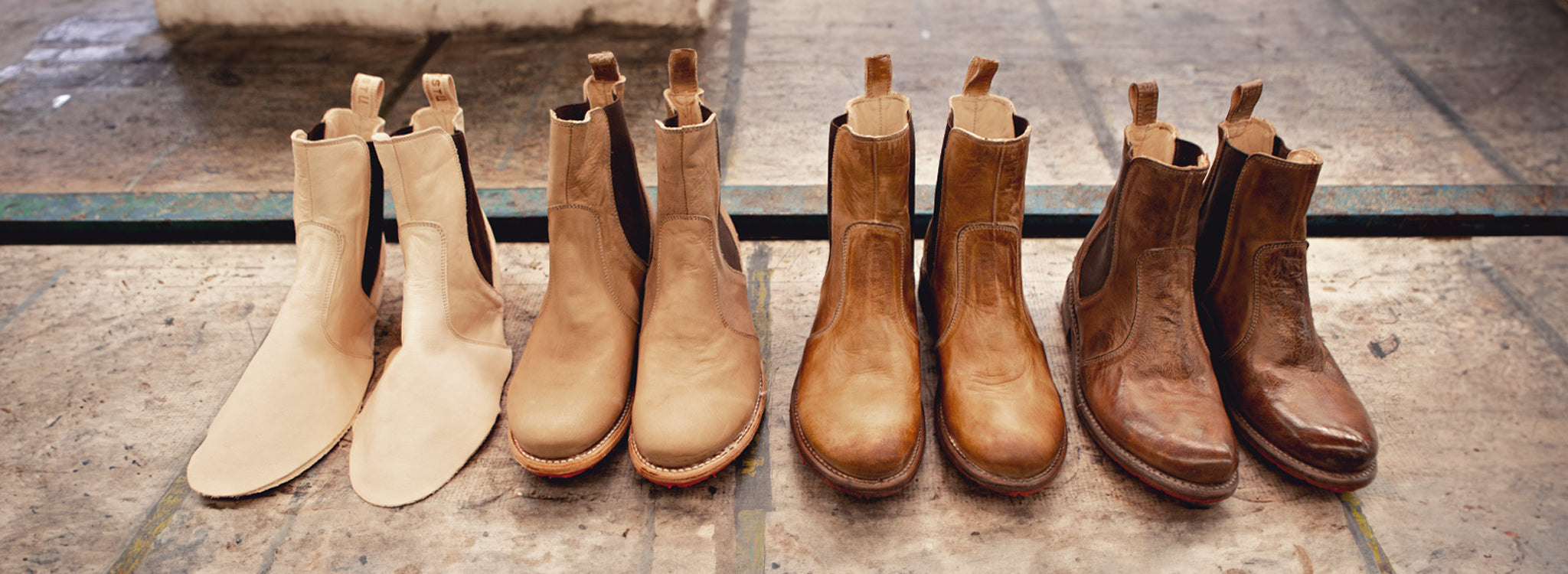 Four pairs of Chelsea boots arranged from unfinished light leather to darker finished brown leather.