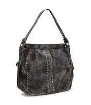 The Packet LTC by Bed|Stü is a distressed black leather tote handbag featuring metal stud detailing, a wide shoulder strap, and a spacious main compartment—perfect as a stylish travel tote.