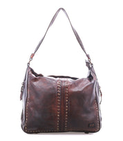 The Packet LTC by Bed|Stü is a large brown leather shoulder tote featuring metal stud detailing, a wide strap, and a slightly worn finish, shown against a white background.