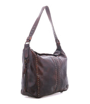 Packet LTC by Bed|Stü is a brown leather shoulder tote bag featuring a single strap, decorative metal studs, and a front zipper pocket, displayed against a white background.