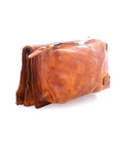 The Parle toiletry bag by Bed|Stü features soft brown leather, zippered compartments, and a durable top zipper, displayed against a white background.