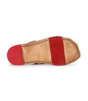 The image shows the sole of the Bed|Stü Path, a tan leather slip-on shoe featuring red rubber grip areas on the toe and heel, designed for comfort during everyday movement.