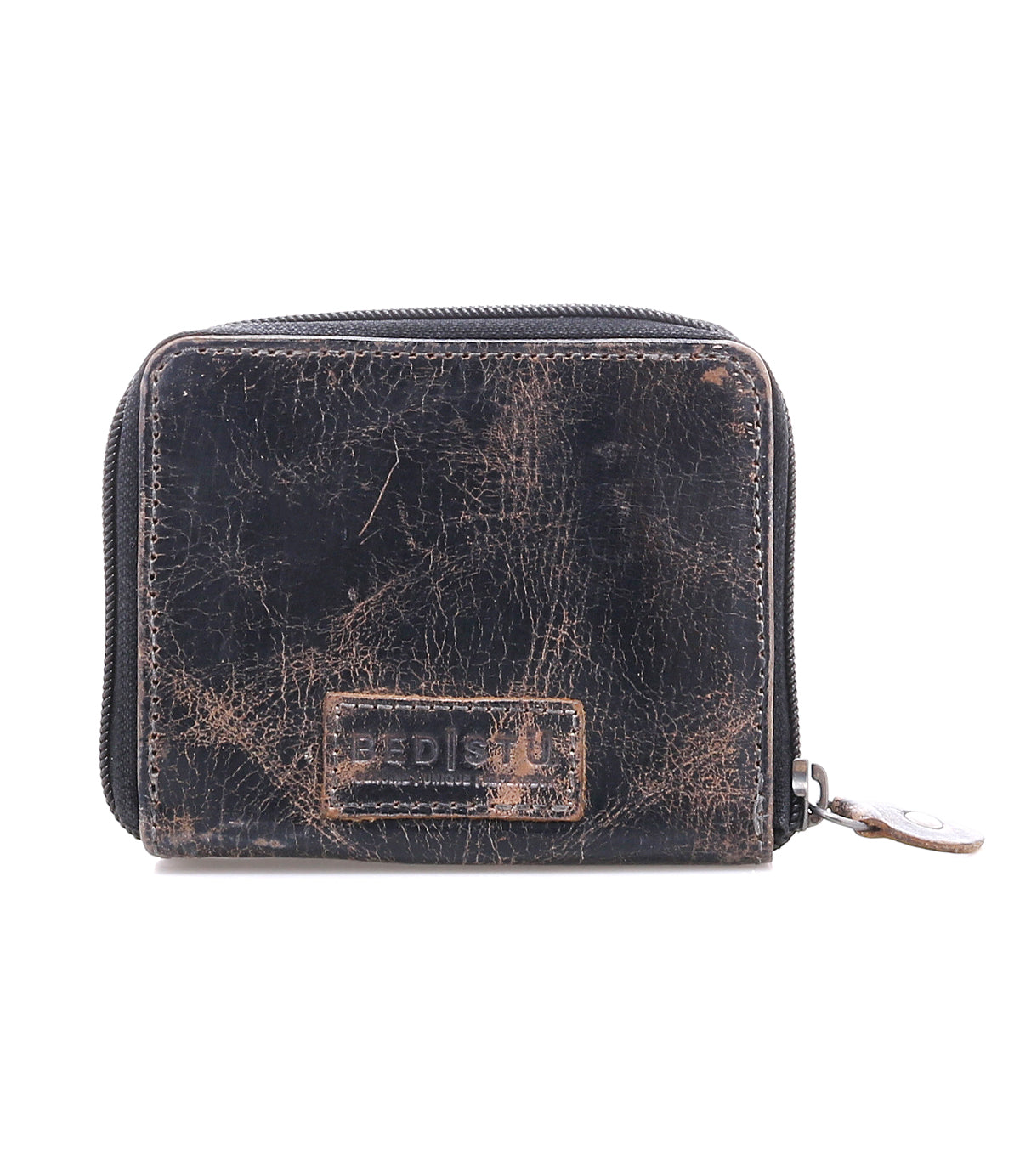 A gently worn black compact leather wallet by Bed|Stü, the Plus model, with visible creases and a textured finish. It features a stitched rectangular patch on the front, a zippered coin pocket, and a zipper pull on the right side.