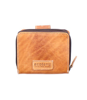 Compact brown leather wallet called "Plus" by Bed|Stü, featuring a zipper closure, front BED|STÜ logo patch, and a convenient zippered coin pocket, displayed against a white background.