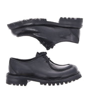 A pair of black leather Portare lace-up shoes by Bed|Stü, featuring thick, rugged soles and shown from the side and bottom angles on a white background, evoke the classic appeal of vintage-inspired boots.