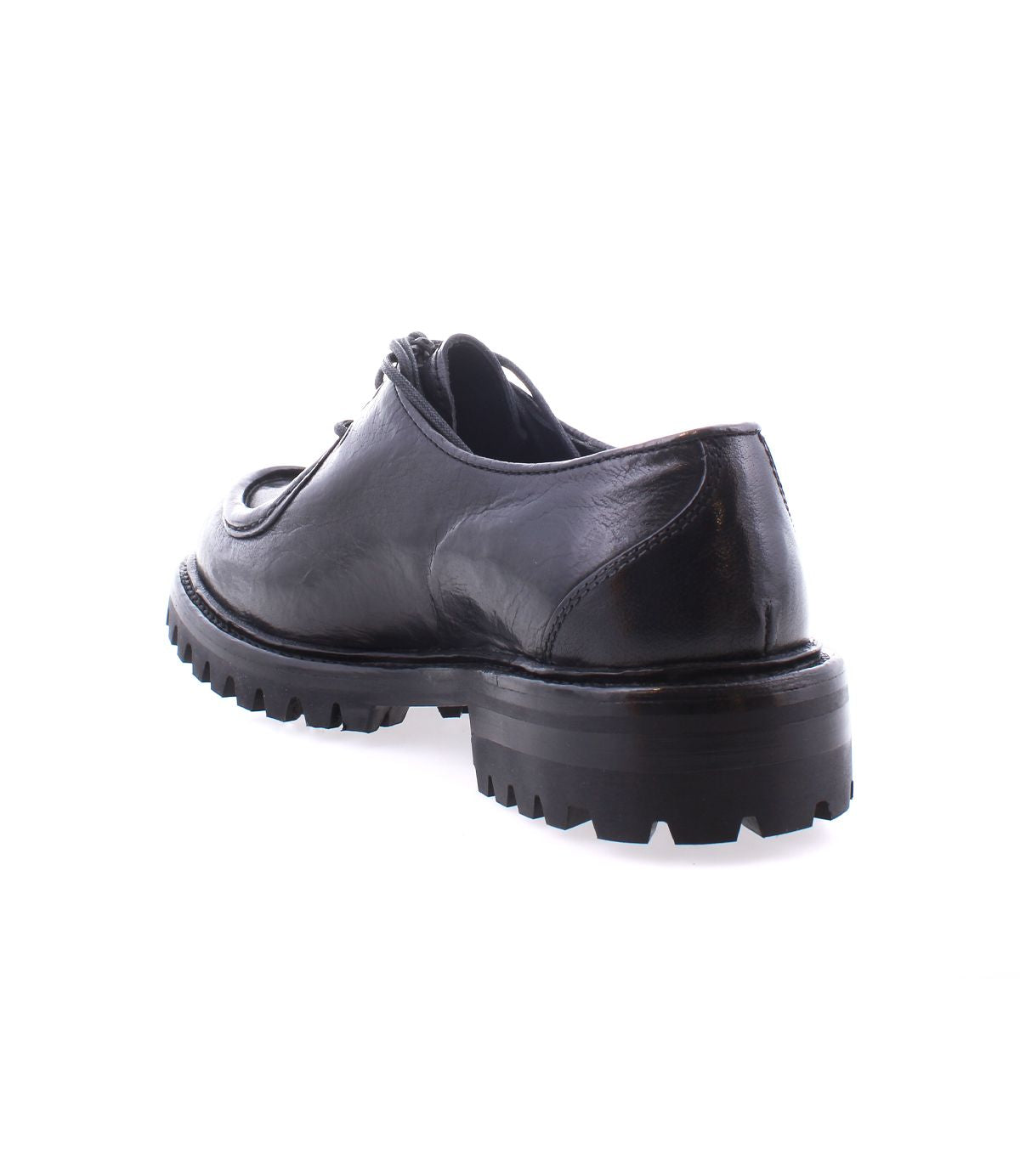 The Bed|Stü Portare, a black leather dress shoe with a thick, rugged sole, is displayed from a rear angle on a white background, merging classic sophistication with the robust charm of vintage-inspired boots.