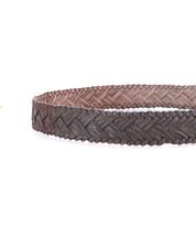 A close-up of the Bed|Stü Proem handwoven brown leather belt with artisan detailing and a vintage metal buckle, displayed against a white background.