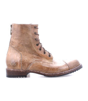 The Bed|Stü Protege is a light brown leather lace-up combat boot with a side zipper and textured rubber sole, displayed in profile against a white background. This durable boot boasts a classic silhouette, making it ideal for everyday wear.