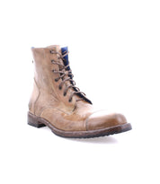 The Bed|Stü Protege boot is a brown leather lace-up combat boot with a round toe, visible stitching, and a low heel, featuring a durable Goodyear welt, shown against a white background.