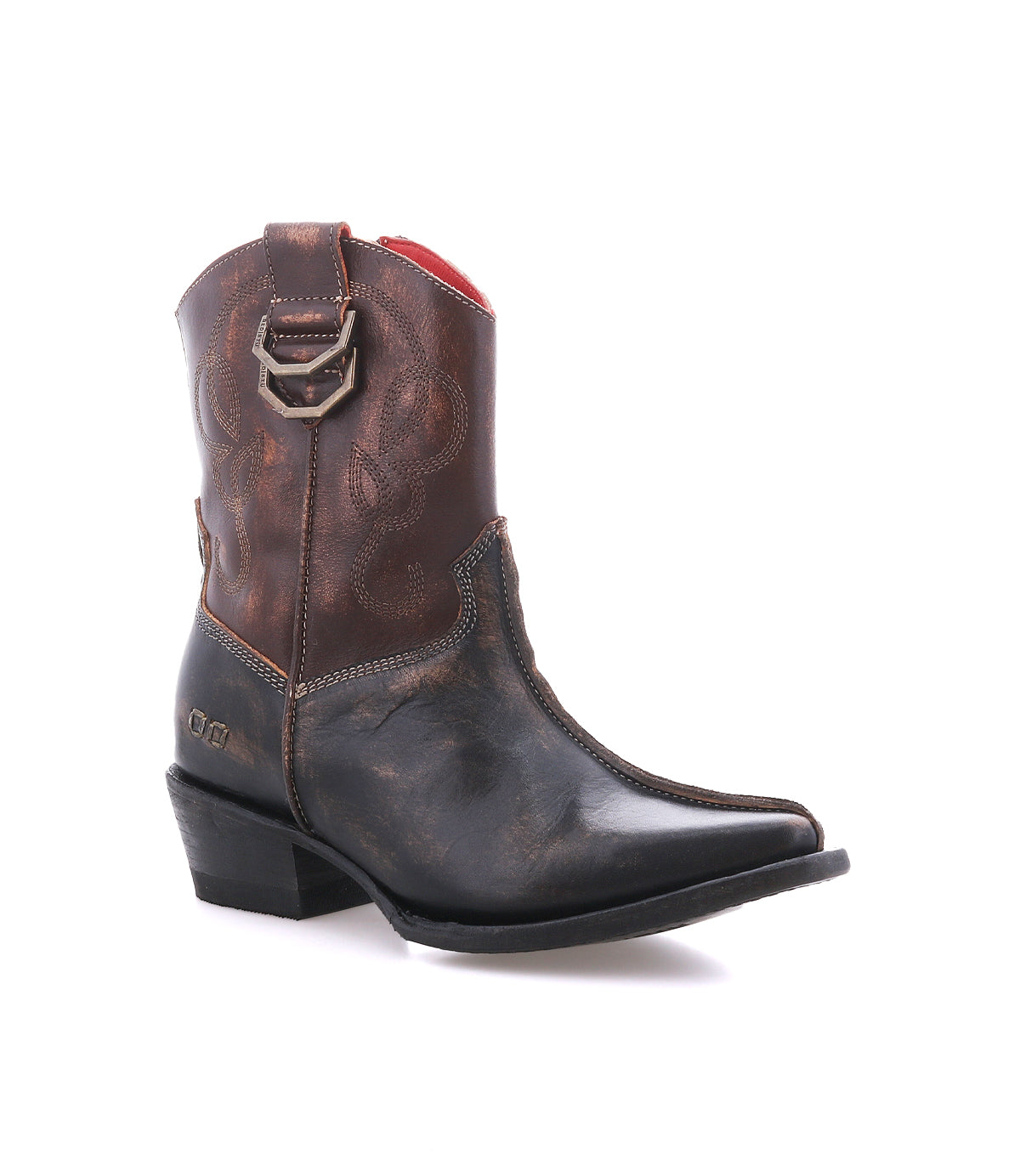 The Bed|Stü Rangeley is a single brown leather cowboy boot featuring decorative stitching and dual D-rings forming a distinctive design near the top, finished with a pointed toe and photographed against a white background.