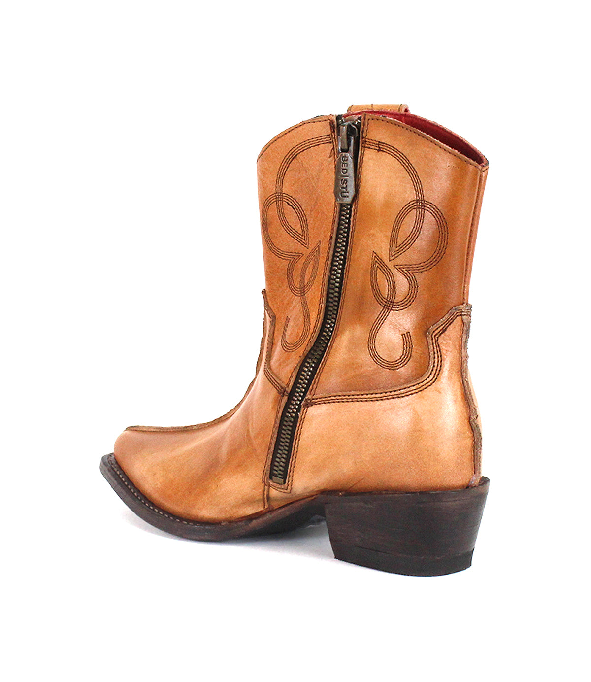 The Bed|Stü Rangeley tan leather cowboy boot showcases decorative stitching and lines, a distinctive design with dual D-rings, a side zipper, pointed toe, and a low stacked heel, displayed against a white background.
