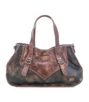 Introducing the Redrock by Bed|Stü: a compact everyday bag crafted from brown distressed leather, featuring dual handles, front buckle accents, and signature Bed|Stü patches on both the upper and lower front panels. This handbag blends a heritage-inspired design with timeless style for effortless daily elegance.
