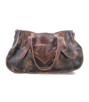 The Bed|Stü Redrock is a distressed brown leather handbag featuring dual handles, visible stitching, and a wide, slightly curved bottom. This compact everyday bag offers a heritage-inspired design for timeless appeal.