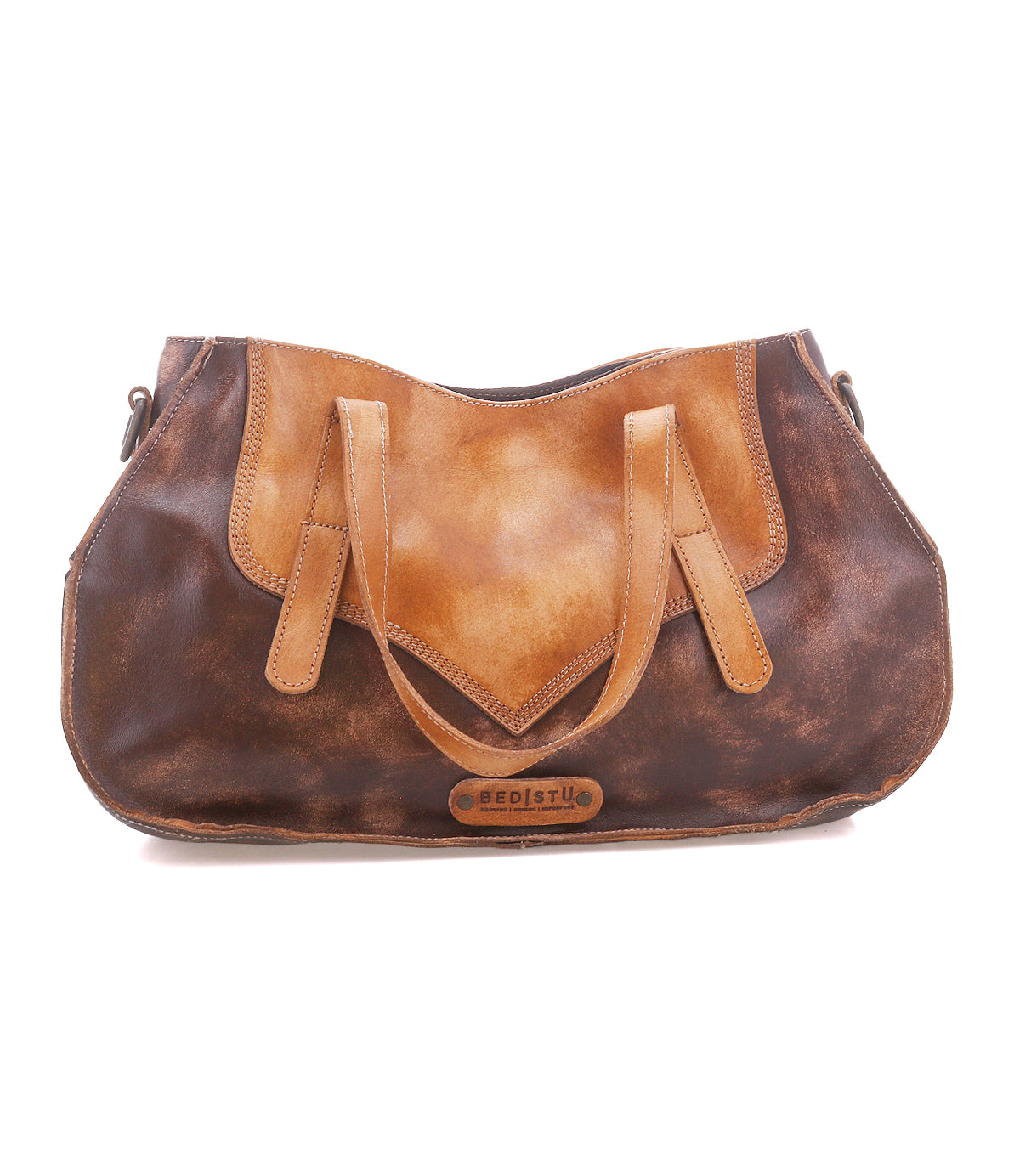 The Bed|Stü Redrock is a brown and tan leather handbag featuring a buckled handle, dual straps, and the Bed|Stü logo on the front. This compact everyday bag highlights a heritage-inspired design and is photographed against a white background.
