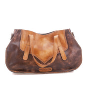 The Bed|Stü Redrock is a brown and tan leather handbag featuring a buckled handle, dual straps, and the Bed|Stü logo on the front. This compact everyday bag highlights a heritage-inspired design and is photographed against a white background.