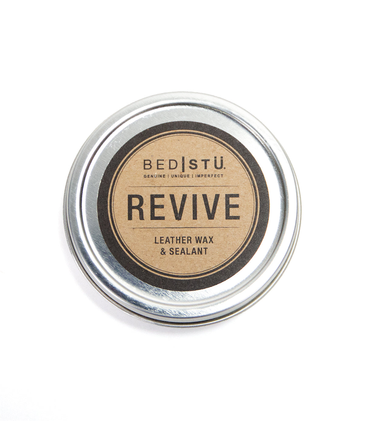 A round metal tin labeled "Bed|Stü Revive Leather Wax/Sealant" features a brown and black design on the lid, offering an ideal leather care solution with its natural wax-based formula.