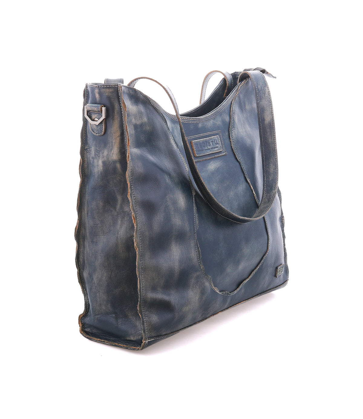 The Bed|Stü Ridgefield is a large, distressed dark blue full-grain leather tote bag featuring a front pocket, shoulder straps, and visible stitching—carefully designed as the perfect daily tote and shown against a white background.