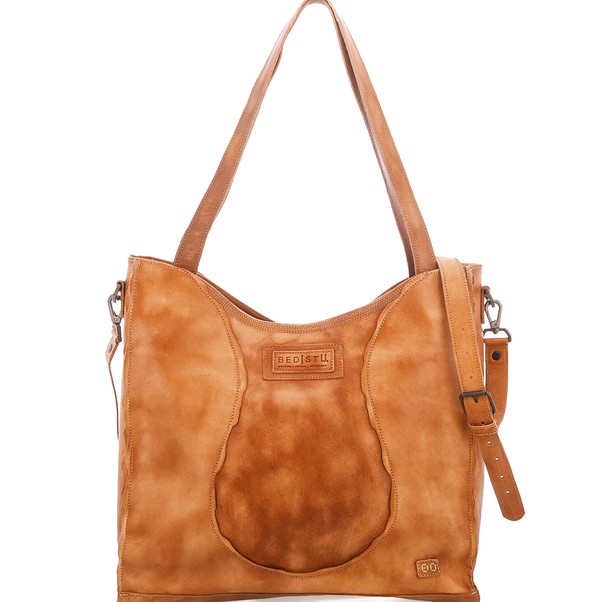 Introducing the Ridgefield by Bed|Stü—a tan full-grain leather shoulder bag featuring two handles, distinctive buckle detailing on the strap, and a front patch adorned with visible stitching and the Bed|Stü logo. Thoughtfully designed as your ideal daily tote, it boasts an organized interior to keep all your essentials neatly arranged.