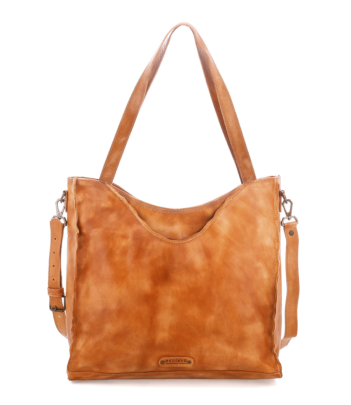 The Ridgefield by Bed|Stü is a tan, full-grain leather handbag featuring shoulder straps, a detachable crossbody strap, and a subtle brand logo on the front. With its smooth, slightly glossy finish and minimalist design, this daily tote offers an organized interior to keep your essentials in place.