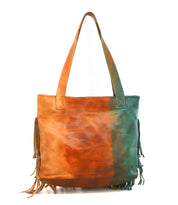 Introducing the Rimes tote by Bed|Stü—a handcrafted leather bag showcasing a distinctive brown and green gradient, long handles, and bold fringe accents along the sides. Designed with a spacious interior, this tote keeps all your essentials organized in style.