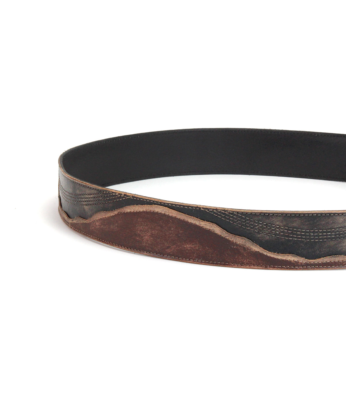 The Bed|Stü Riven is a black leather belt featuring a brown, distressed, wavy pattern along the lower edge. Shown looped against a white background, it’s an ideal everyday accessory that combines durability with classic style.
